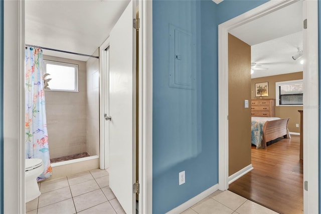 bathroom with tile patterned flooring, electric panel, toilet, and a shower with shower curtain