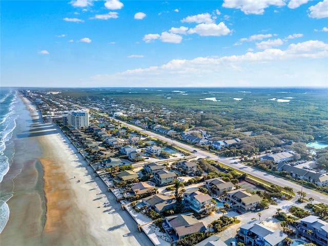 drone / aerial view with a water view and a beach view