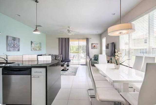 kitchen featuring hanging light fixtures, white cabinetry, stainless steel dishwasher, and light tile patterned floors