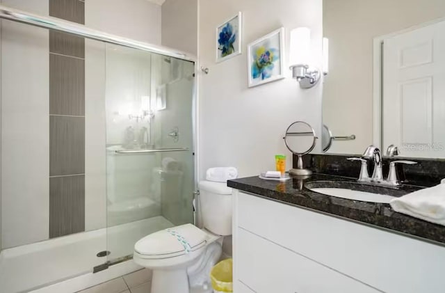 bathroom featuring vanity, tile patterned floors, a shower with door, and toilet