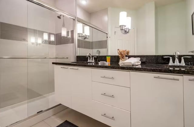 bathroom featuring vanity, tile patterned floors, and walk in shower