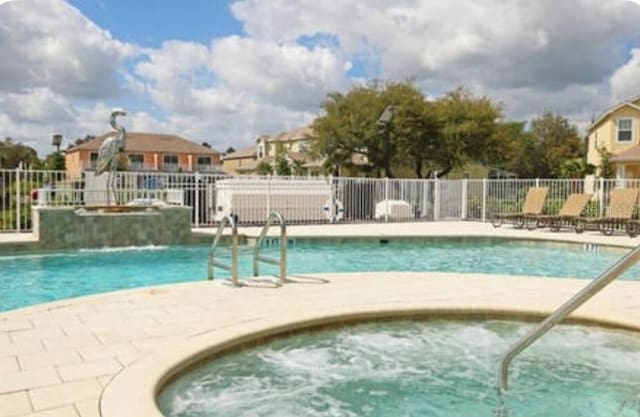 view of swimming pool featuring a hot tub