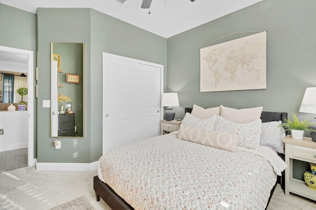 bedroom featuring ceiling fan, a closet, and light carpet