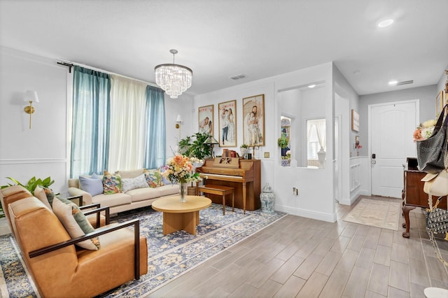 living room featuring a chandelier and light wood-type flooring