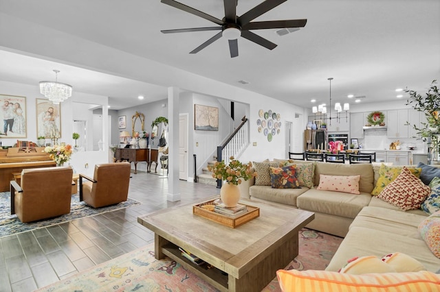 living room featuring wood-type flooring and ceiling fan with notable chandelier