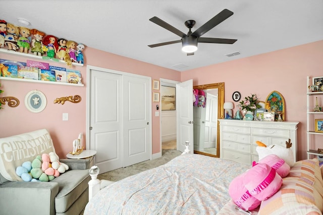 bedroom featuring light colored carpet, ceiling fan, and a closet