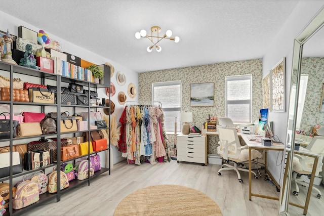 home office featuring a notable chandelier, light hardwood / wood-style flooring, and a textured ceiling