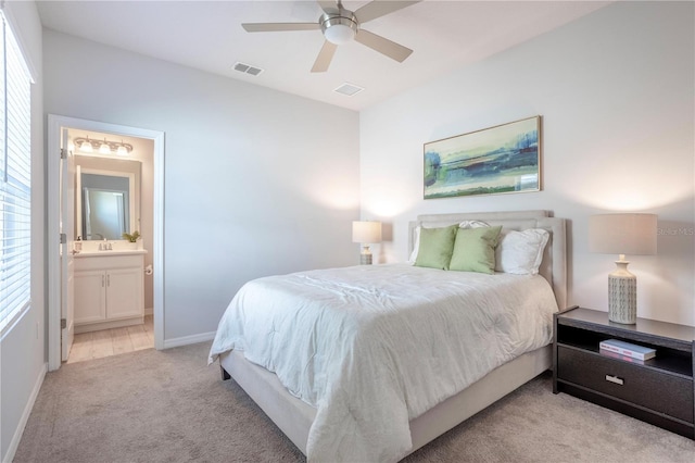 bedroom featuring baseboards, visible vents, ceiling fan, light colored carpet, and connected bathroom