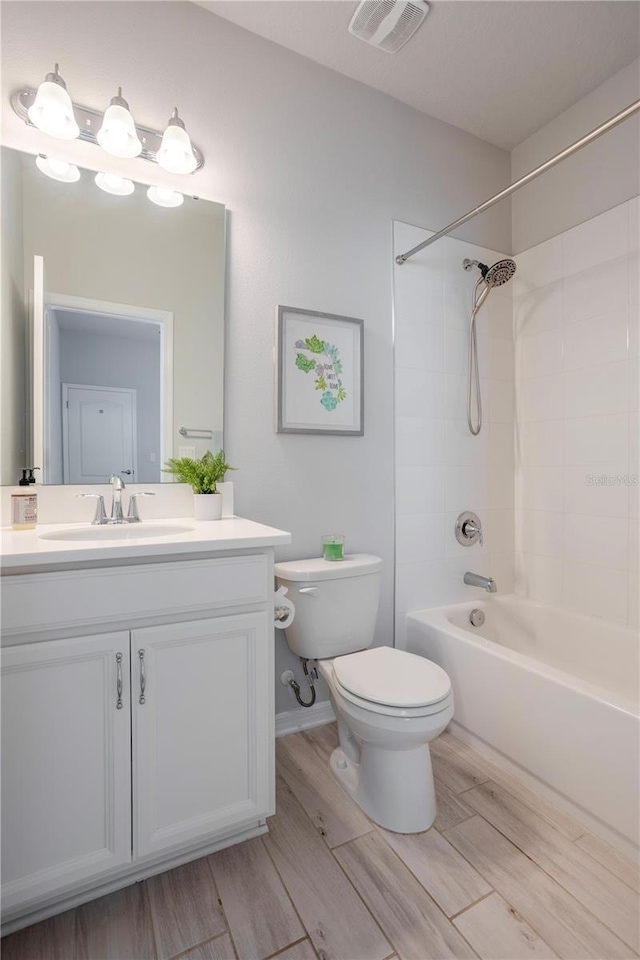 full bathroom featuring visible vents, wood tiled floor, toilet, shower / bath combination, and vanity