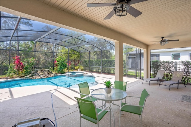 view of swimming pool with glass enclosure, a patio area, a pool with connected hot tub, and ceiling fan