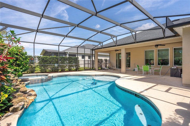 view of pool with a pool with connected hot tub, a lanai, a ceiling fan, and a patio area