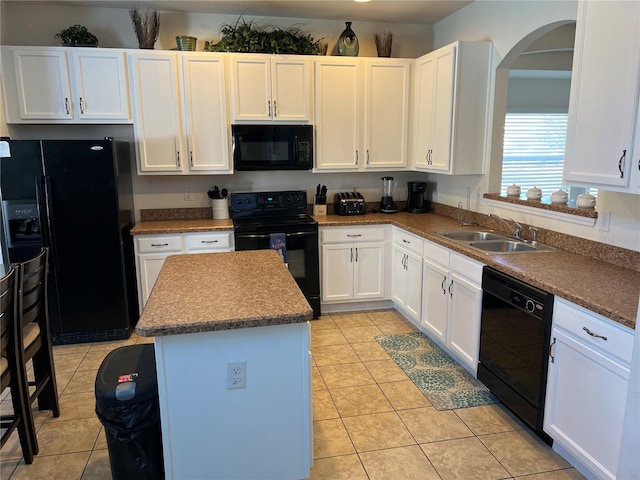 kitchen featuring a kitchen island, sink, white cabinets, light tile patterned floors, and black appliances