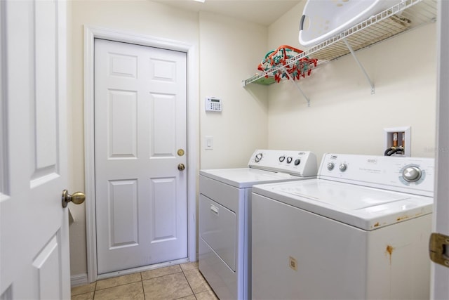 clothes washing area with separate washer and dryer and light tile patterned floors