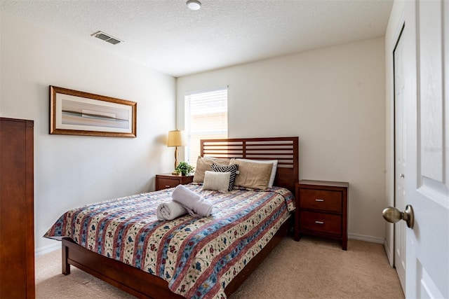 bedroom with light colored carpet, a closet, and a textured ceiling