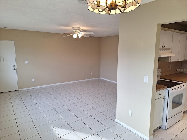 kitchen with light tile patterned floors, white cabinets, white range with electric cooktop, ceiling fan with notable chandelier, and backsplash