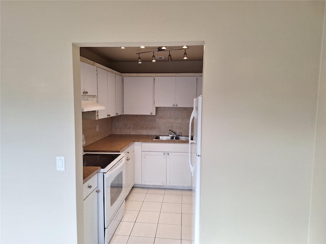 kitchen with tasteful backsplash, light tile patterned floors, white cabinets, and white appliances