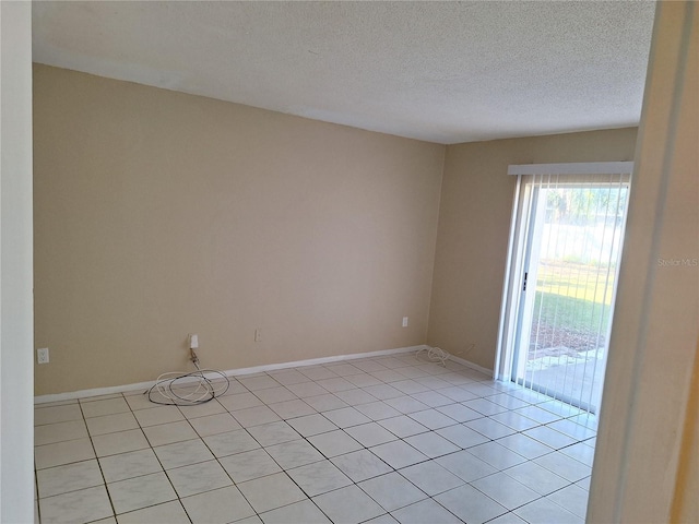 spare room with light tile patterned flooring and a textured ceiling