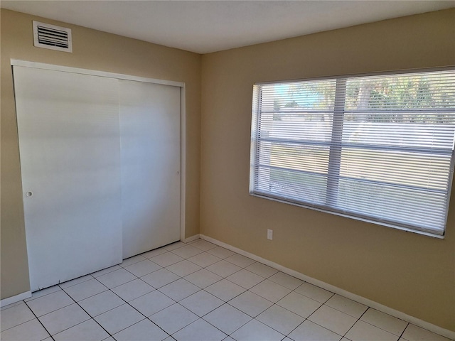 unfurnished bedroom featuring light tile patterned floors and a closet