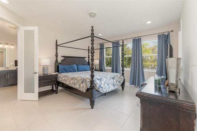 bedroom with sink, light tile patterned floors, and ensuite bath