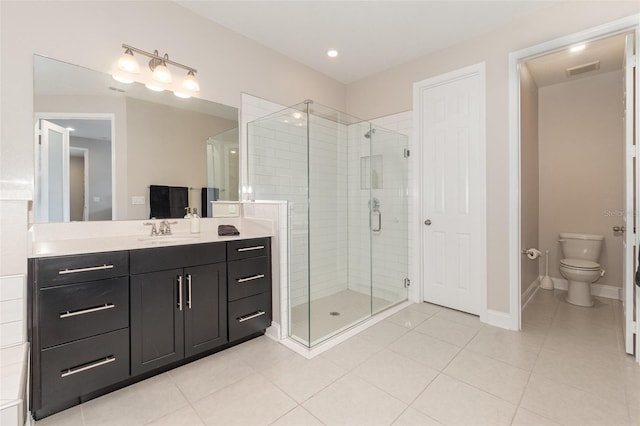 bathroom featuring walk in shower, vanity, toilet, and tile patterned flooring