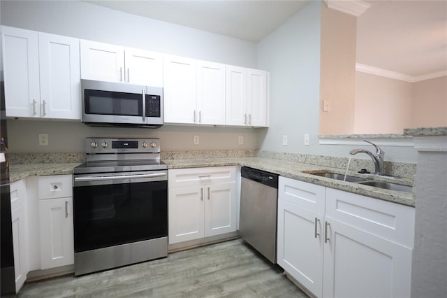 kitchen featuring sink, white cabinets, stainless steel appliances, crown molding, and light wood-type flooring