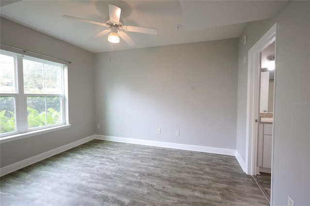 unfurnished room with dark hardwood / wood-style flooring and ceiling fan