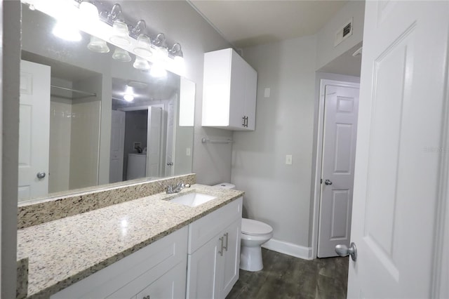 bathroom featuring hardwood / wood-style flooring, vanity, walk in shower, and toilet