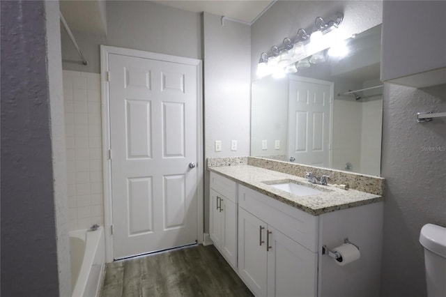 full bathroom featuring vanity, wood-type flooring, tub / shower combination, and toilet