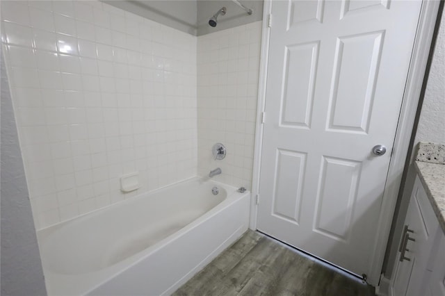 bathroom with tiled shower / bath, wood-type flooring, and vanity