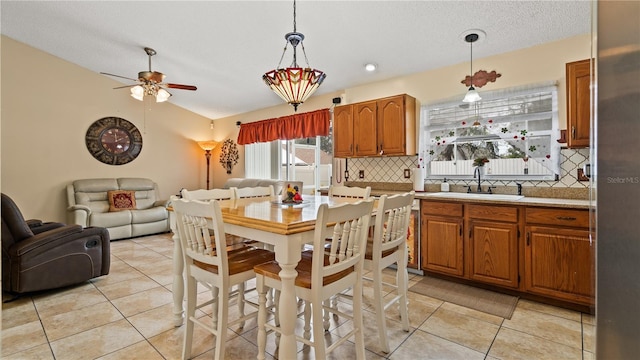 kitchen with lofted ceiling, sink, backsplash, a textured ceiling, and decorative light fixtures