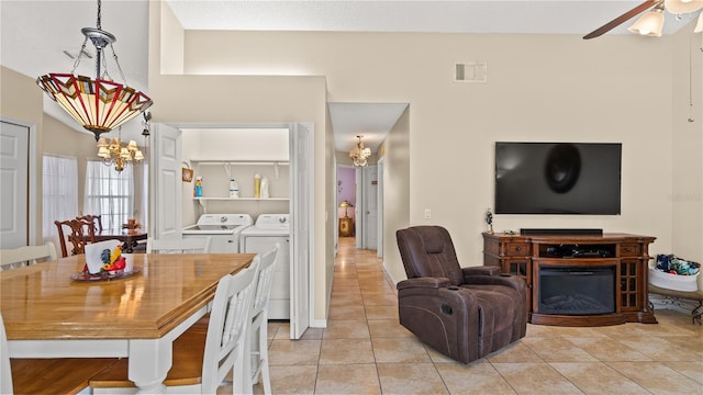 dining area with ceiling fan with notable chandelier, light tile patterned floors, and washer and clothes dryer