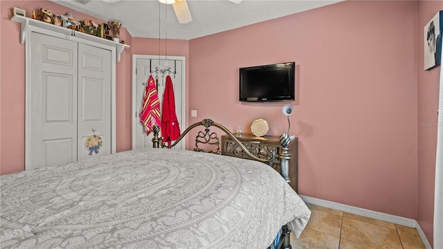 tiled bedroom featuring ceiling fan, a closet, and a textured ceiling