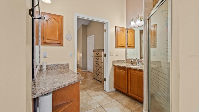 bathroom with walk in shower, vanity, and tile patterned flooring