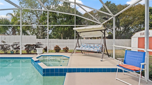 view of swimming pool with a shed, a patio area, an in ground hot tub, and glass enclosure