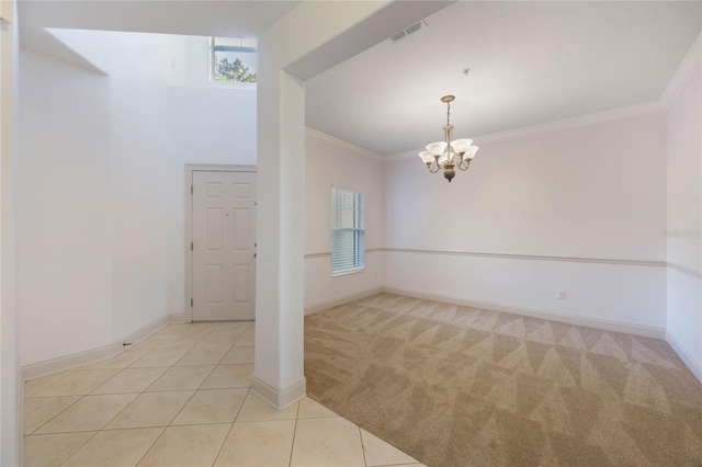 carpeted empty room with ornamental molding and a notable chandelier