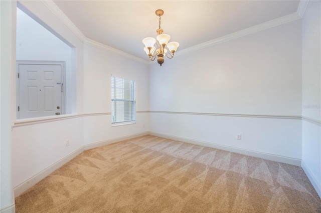 carpeted spare room featuring ornamental molding and an inviting chandelier