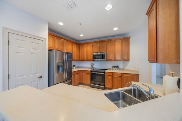 kitchen featuring sink, kitchen peninsula, and appliances with stainless steel finishes