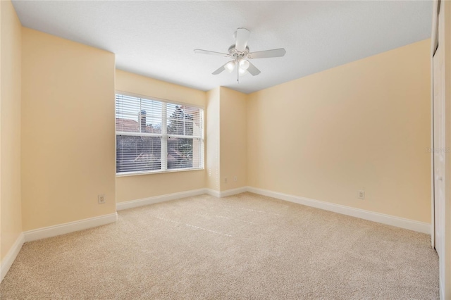 spare room with light colored carpet and ceiling fan