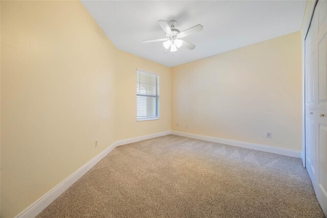 empty room with ceiling fan and carpet