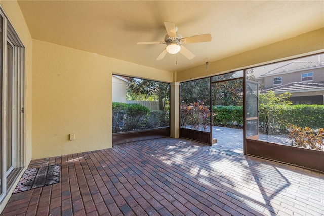 unfurnished sunroom with ceiling fan