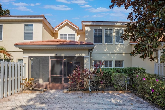 back of property featuring a patio and a sunroom