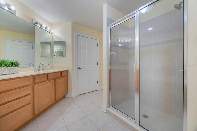 bathroom featuring tile patterned floors, an enclosed shower, and vanity