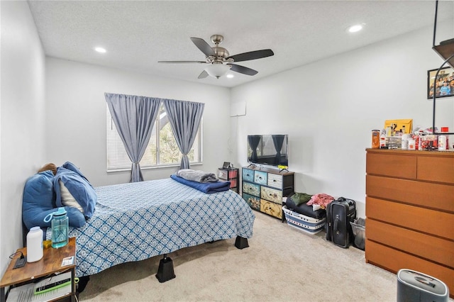 carpeted bedroom with ceiling fan and a textured ceiling