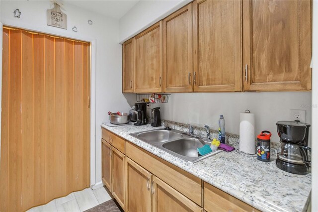 kitchen with light stone counters and sink