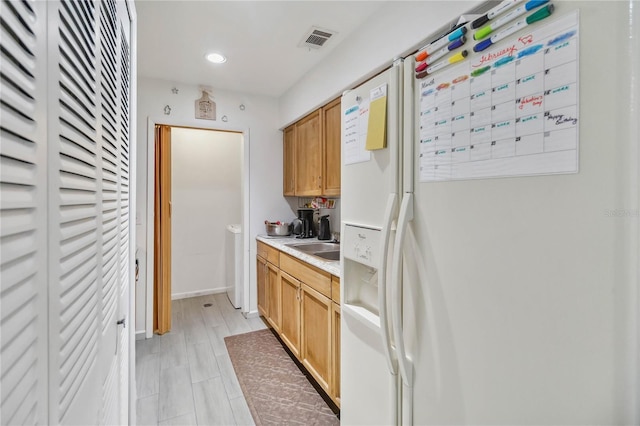 kitchen with white refrigerator with ice dispenser and sink