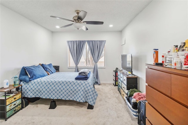 carpeted bedroom featuring a textured ceiling and ceiling fan