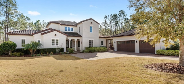 mediterranean / spanish-style house featuring a garage and a front lawn