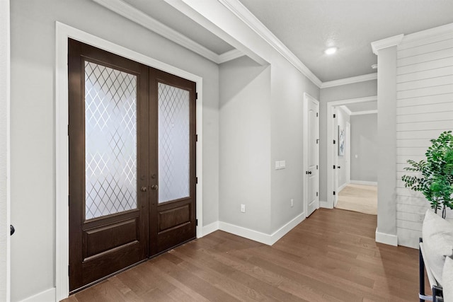 entrance foyer with hardwood / wood-style floors, crown molding, and french doors