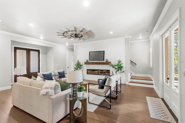 living room with wood-type flooring, ornamental molding, ceiling fan, and french doors