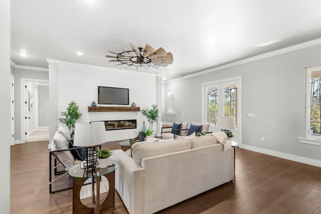 living room with ornamental molding, dark wood-type flooring, a wealth of natural light, and ceiling fan